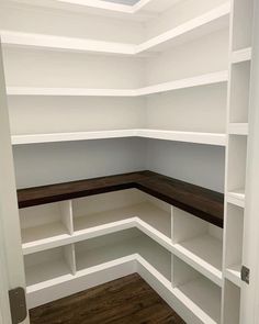 an empty room with white shelving and wood flooring in the corner is shown