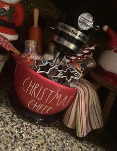 a red bowl filled with christmas items on top of a counter