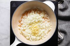 onions are being cooked in a pot on the stove top with a cloth next to it