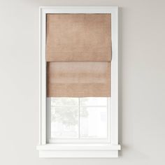 a white window with a tan roman blind