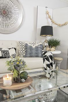 a living room filled with furniture and a glass table topped with a vase full of flowers