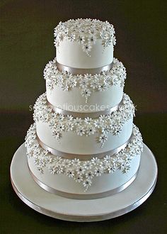 a three tiered wedding cake with white frosting flowers