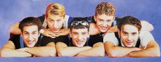 a group of young men posing for a photo in front of a purple background with their arms around each other