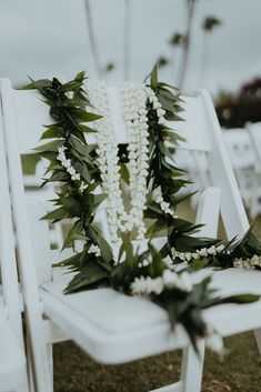 a white chair with flowers and greenery on it