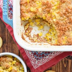 a casserole dish filled with corn next to crackers