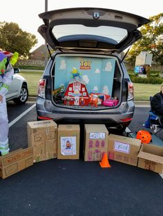 the trunk of a car is filled with cardboard boxes and clowns are standing next to it