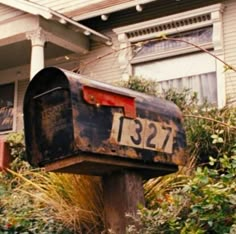 an old mailbox sitting in front of a house