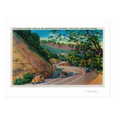 an old postcard with cars driving down the road in front of trees and hills