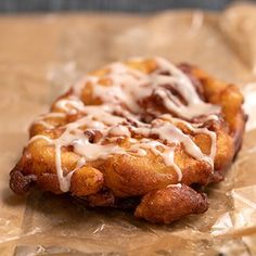 a pastry with icing sitting on top of wax paper