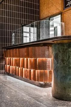 an empty lobby with brick walls and metal railings on either side, in front of a window