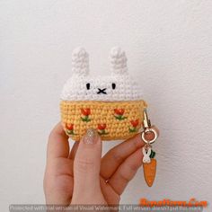 a hand holding a small crocheted keychain shaped like a food item