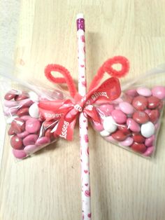 a candy bar wrapped in cellophane and tied to a stick with a bow