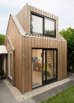 a small wooden house sitting on top of a lush green field