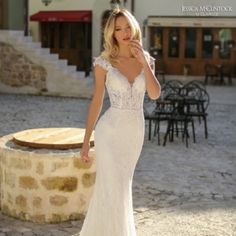 a woman in a white wedding dress posing for the camera with her hand on her face