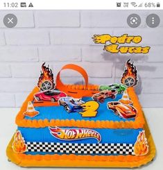 a birthday cake with cars on it is in the shape of a race car and flames