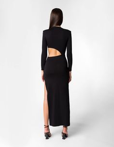 There is an undeniable charm and beauty associated with Yala. This tailored dress has a figure contouring fit with padded shoulders to enhance the ideal craftsmanship. It has an O-neckline with long fluted sleeves and a sultry side skit on the ankle-length hem. The skin bearing cutout on the waist is detailed with a decorative strap. Slips on Long sleeves Side cut-out at the hem Padded shoulders Band with golden buckle Made in RomaniaComposition: 95% Ecovero Viscose, 5% ElastaneStyle number: DVL Side Cuts, Tailored Dress, Ankle Length, Two Piece Pant Set, Cold Shoulder Dress, Two Piece Skirt Set, Cut Out, Black Dress, Slip On