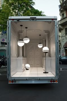 the back of a truck with its doors open and three lights on it's side