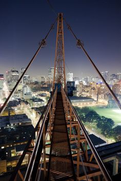 a view from the top of a tall tower at night, looking down on a cityscape