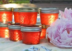 pink flowers and mason jars are sitting on a table