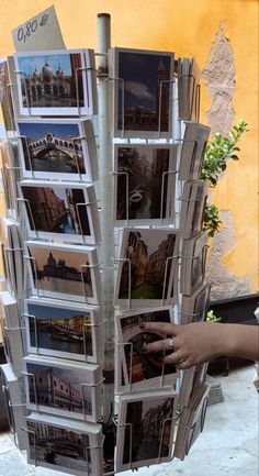 a person is holding up a magazine rack with pictures on it and the bottom half has been folded open