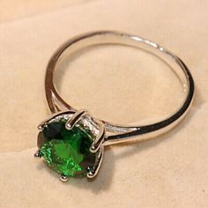 a close up of a ring with a green stone