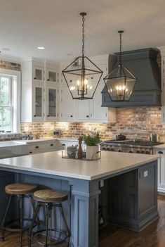 a large kitchen with an island in the middle and two stools at the end