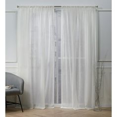 a white curtain hanging on the side of a wall next to a chair and window