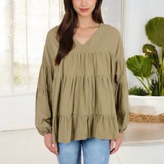 Embrace effortless style with the Anna-Kaci Women's V-Neck Tiered Babydoll Top. This top features a flattering V-neckline and a relaxed, tiered babydoll silhouette that adds a touch of bohemian flair to your look. The long puff sleeves with elastic cuffs provide a romantic touch, making this top perfect for both casual days and dressier occasions. Pair it with your favorite jeans or leggings for a chic, comfortable outfit that stands out in any setting. Casual Flowy V-neck Peasant Top, Casual Billowy V-neck Tops, Spring V-neck Peasant Top With Relaxed Fit, Spring V-neck Relaxed Fit Peasant Top, Flowy V-neck Casual Peasant Top, Cotton V-neck Peasant Top For Fall, Fall V-neck Peasant Top With Ruffles, Green V-neck Peasant Top For Fall, Flowy V-neck Peasant Top For Day Out