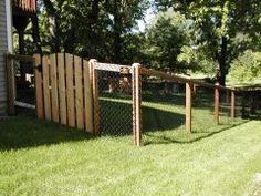 the fence is made out of wood and has a gate on one side that leads to an apartment