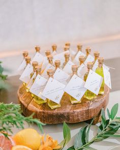 small bottles of olive oil and oranges on a cutting board with place cards in them