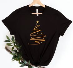 a black t - shirt with a gold christmas tree on the front and stars on the back