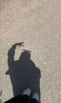 the shadow of a person's hand on asphalt