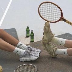 the legs and feet of two people with tennis rackets