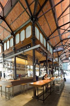 the inside of a restaurant with tables and benches