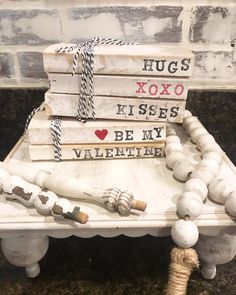 a stack of books sitting on top of a white bench next to a roped heart