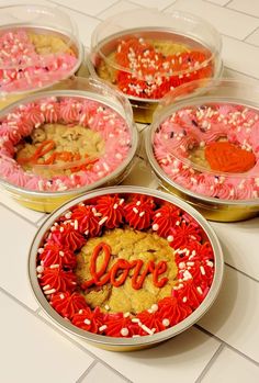 four tins filled with cake and sprinkles on top of a table