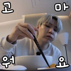 a young man eating food with chopsticks in front of him