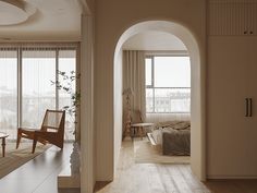 a large bedroom with arched doorways leading to another room that has a bed and chairs in it