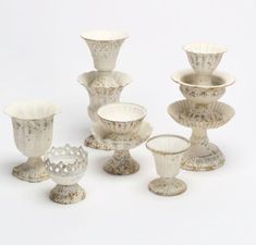 an assortment of vases and bowls are shown in this image, including one with a crown on it