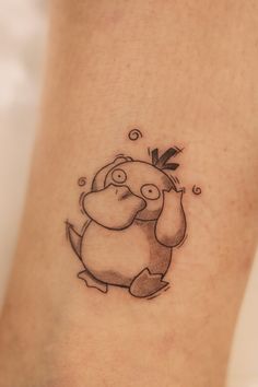 a tattoo on the leg of a person with a small bear and arrow in it