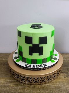 there is a green cake with black numbers on the top and one number on the bottom