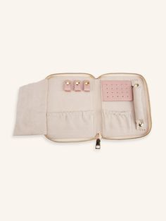 an open white purse with pink handles and two small clips in the inside, on a white background