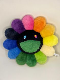 a multicolored flower shaped brooch sitting on top of a white table