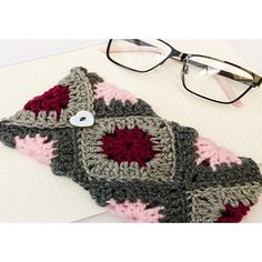 a pair of glasses sitting on top of a notebook next to a crocheted object