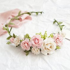 pink and white flowers are arranged in a floral headpiece on a sheet of paper