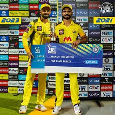 two men standing next to each other holding a trophy