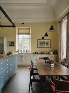 a kitchen with blue cabinets and wooden table