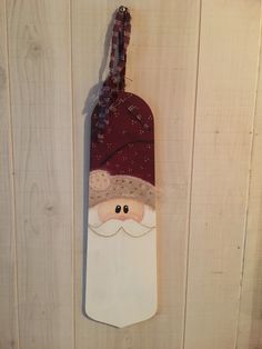 a santa claus ornament hanging on a wooden wall next to a white door