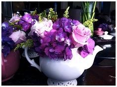 purple and pink flowers in a white pitcher on a table