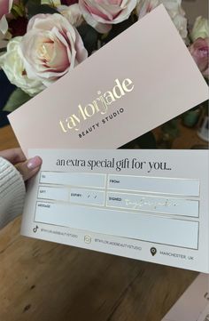 someone is holding up a gift card with flowers in the background and text that reads, taylormade beauty studio an extra special gift for you